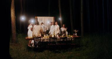 A group of people standing around a table in the woods video