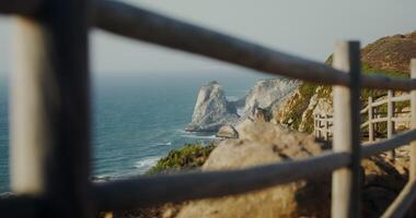 Panoramic view of the sea washing the rocky shores and ledges. View from the top of the mountain from the observation deck through the fence video