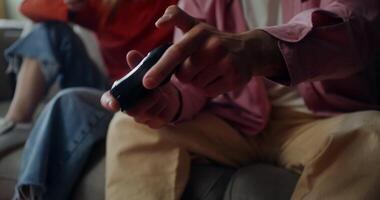 Two people are playing games at home. Close-up of male hands with a joystick, no face video