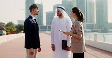 Two business people talking to each other in front of a city video