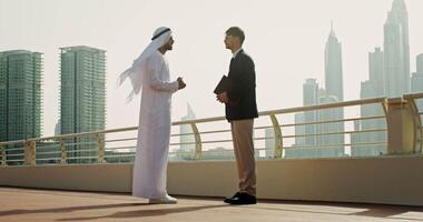 Two men in business attire talking on a bridge video
