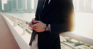 A man in a suit and tie holding his phone video
