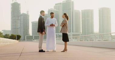 Three business people standing on a bridge with skyscrapers in the background video