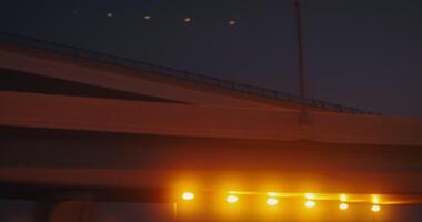 Road junction illuminated by lights at night, from the window of a car moving under the bridge video