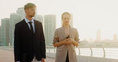 Two people in business attire walking along a bridge video