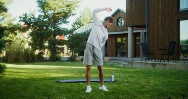 A man is doing a yoga pose in the yard video