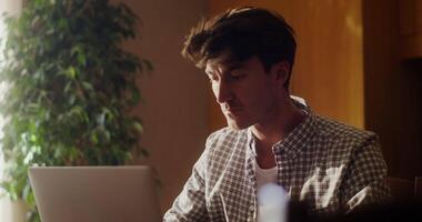 A man is sitting at a table with a laptop video