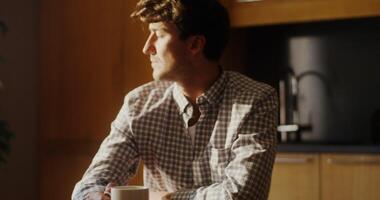 A man sitting at a table with a cup of coffee video