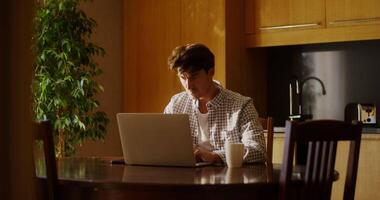 A man sitting at a table with a laptop computer video