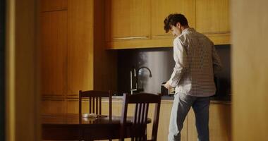 A man standing in a kitchen with a table and chairs video
