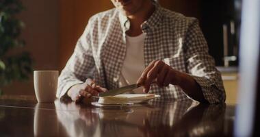 A man sitting at a table with a knife and a cup video