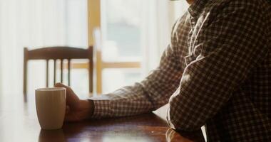 A man sitting at a table with a cup of coffee video