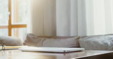 A laptop sits on a wooden table in front of a window video