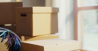 Moving boxes stacked on a table in front of a window video