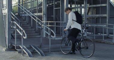 A man with a backpack is riding a bike down stairs video