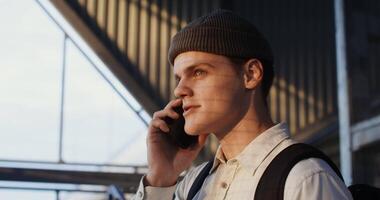 A man in a beanie talking on a cell phone video