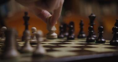 A person is playing a chess game on a board video