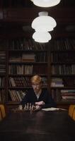 A man sitting at a table with chess pieces on it video