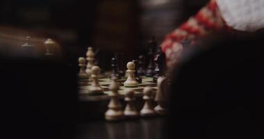 A close up of a chess board with a person playing video