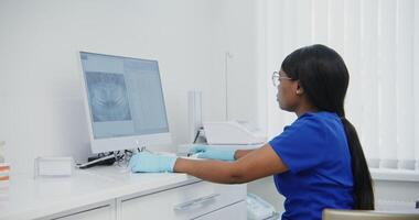 A woman in blue shirt and gloves is working on a computer video