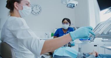 A woman is sitting in a dental chair with a mask on video