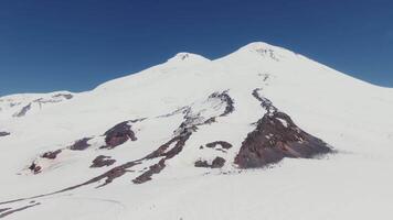 A large snow covered mountain with a person on skis video