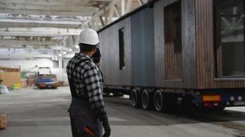 Construction worker directing modular home transportation process video