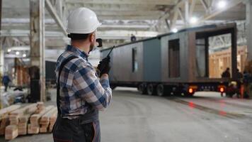 Construction worker directing modular home loading process video
