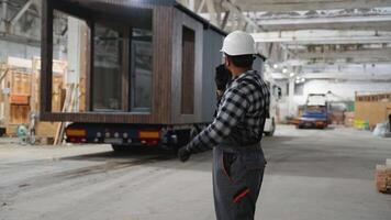 Indian worker directing modular home transportation process video