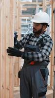 Carpenter assembling wooden frame at modular home factory video