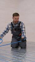 Worker installing underfloor heating in modular home video
