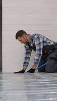 Worker installing underfloor heating in modular home video