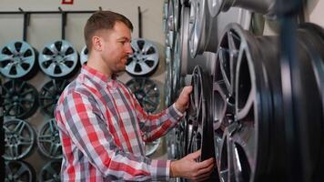 Man selecting alloy wheels in an auto parts store video