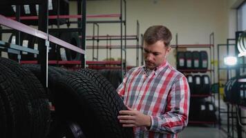 Man inspecting a tire before purchase in auto parts store video