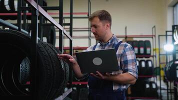 Worker in uniform conducting tire inventory in warehouse video