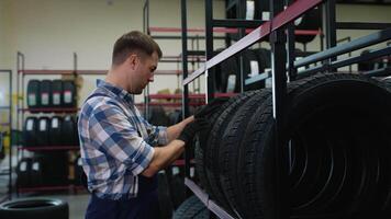 Salesman taking a tire from the shelf for a customer video