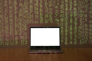 Laptop with space for your message on wooden table over binary code background in dark room. photo