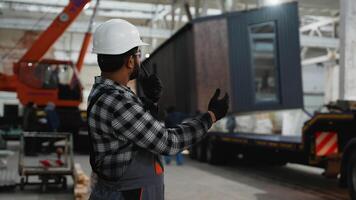 Indian worker supervising modular home loading with crane video