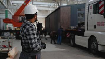 Indian worker coordinating modular home loading process video