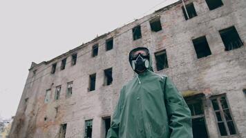 Environmentalist in protective suit and gas mask. Man in gas mask near abandoned destroyed building video