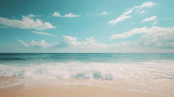 Azure Ocean Waves on Golden Sandy Beach Under a Bright Blue Sky with White Clouds photo