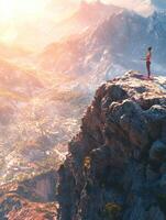 A woman standing on top of a mountain with the sun setting behind her photo