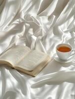 Cozy afternoon with tea and an open book on soft fabric photo