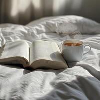 Warm cup and open book on a cozy bed in morning light photo