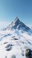 Mountain peak surrounded by snow-covered terrain on clear day photo