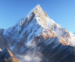Snow-capped peak rising above rugged mountain range photo