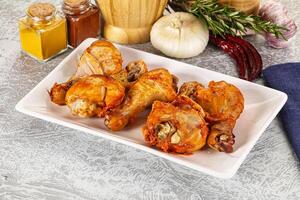 A plate of chicken wings on a table with spices photo
