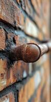 Pipe leak on an old brick wall in a dimly lit area photo