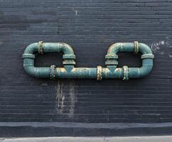Leak pipe on a dark wall with rusted fixtures photo