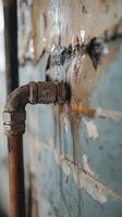 Leak from old pipe causing damage on the wall photo